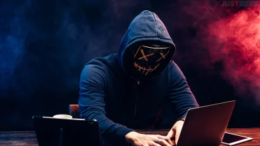 Personne masquée en train de lancer une cyberattaque depuis un ordinateur portable
