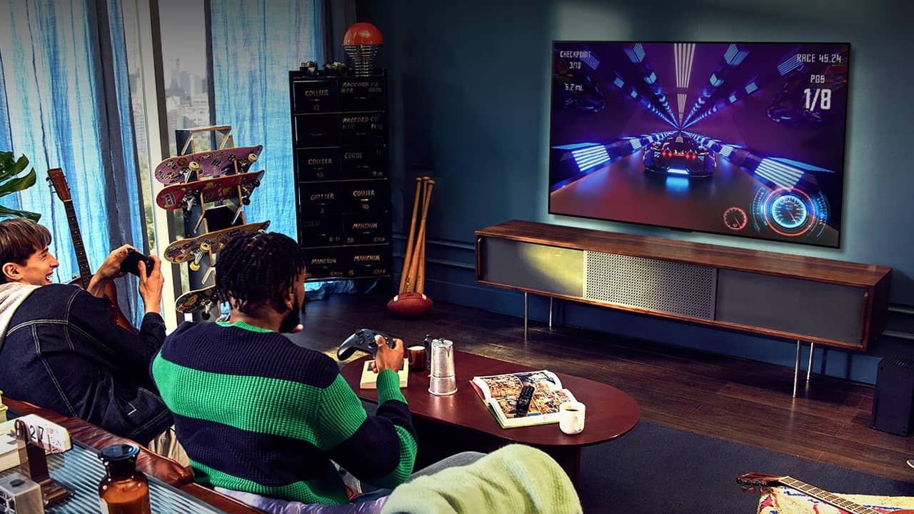 Deux jeunes hommes jouent aux jeux-vidéo sur une TV