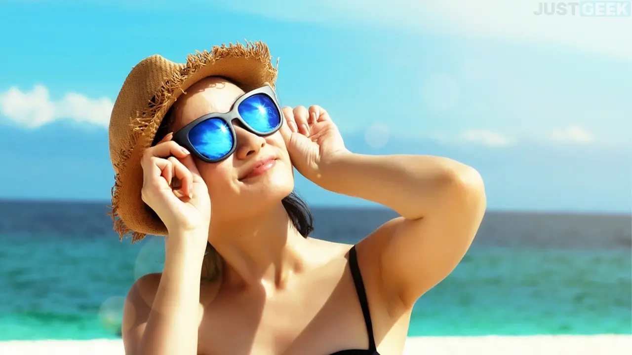 Une jeune femme sur la plage regardant le soleil avec des lunettes de soleil