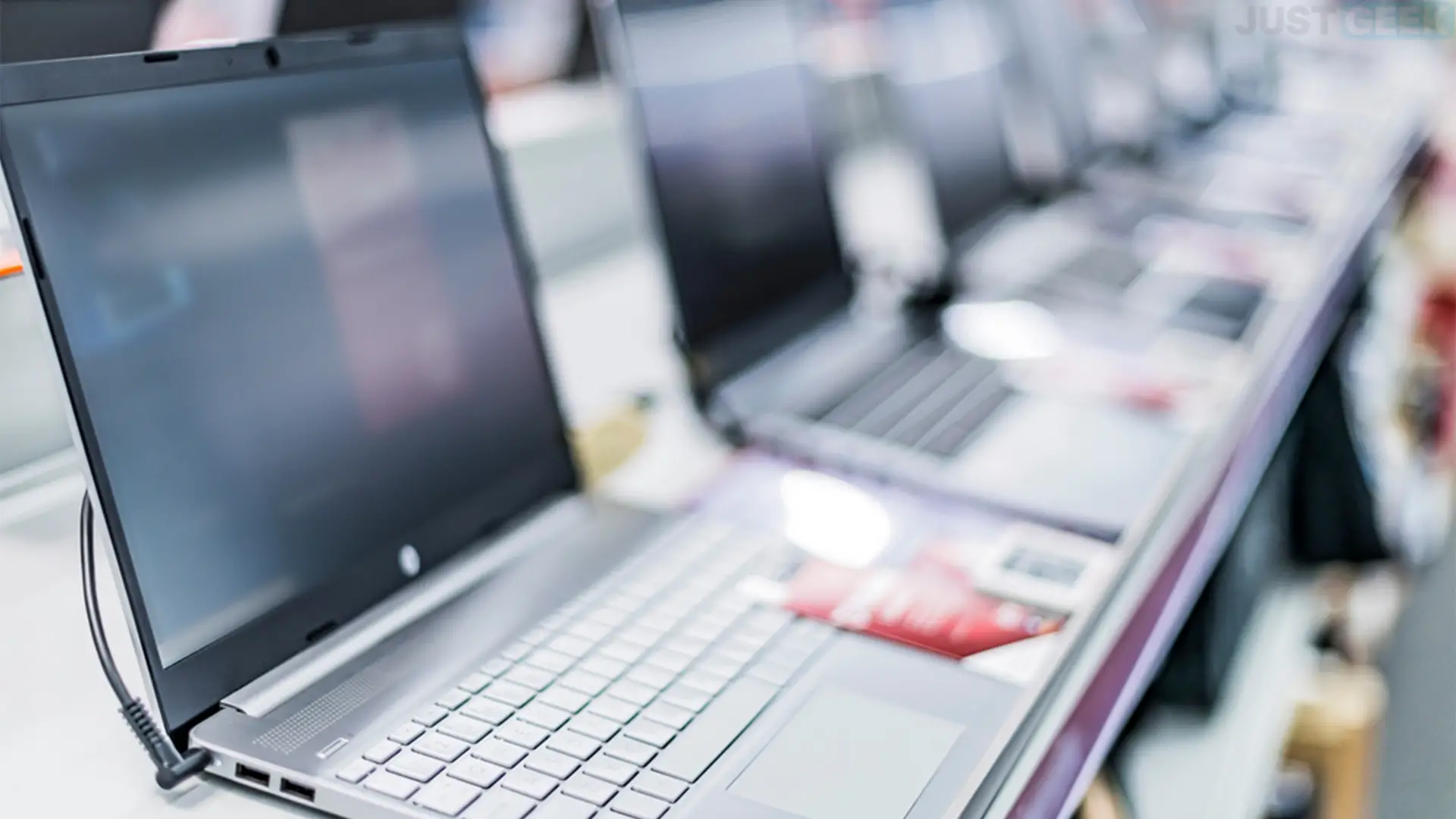 Ordinateurs portables d'occasion exposés en magasin, alignés sur un comptoir