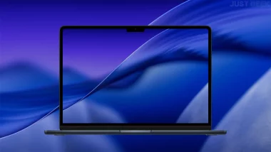 Aperçu du fond d’écran macOS Tahoe 26 en mode sombre affiché sur un MacBook
