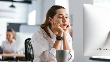 Jeune femme en difficulté devant son ordinateur, semblant bloquée face à une tâche informatique au bureau