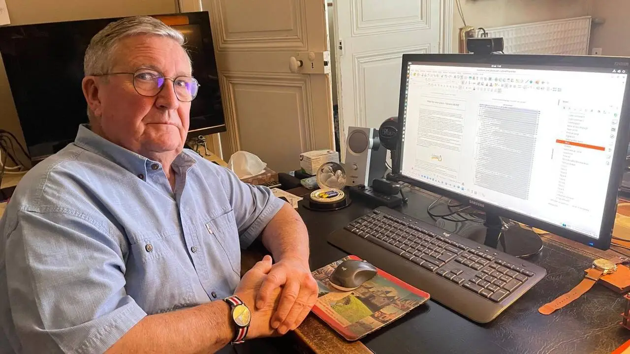 Xavier Théry assis à son bureau devant son ordinateur équipé de logiciels libres
