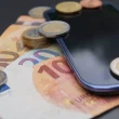 Billets et pièces en euros posés sur un smartphone illustrant le coût des forfaits mobile en France