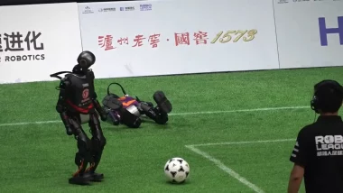 Robots humanoïdes jouant au football lors du tournoi RoBoLeague 2025 en Chine, avec l’un d’eux à terre après une chute