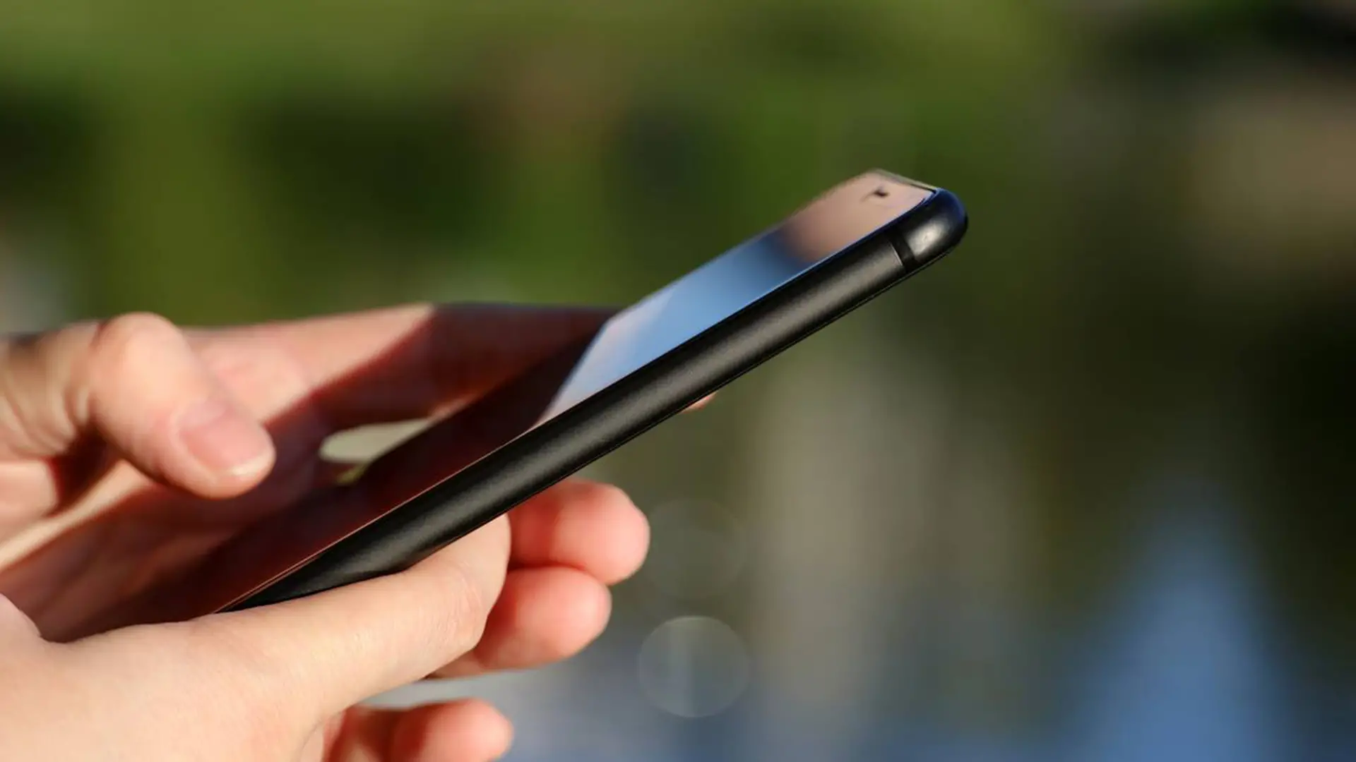 Personne tenant un smartphone, illustrant la comparaison des forfaits mobile en ligne